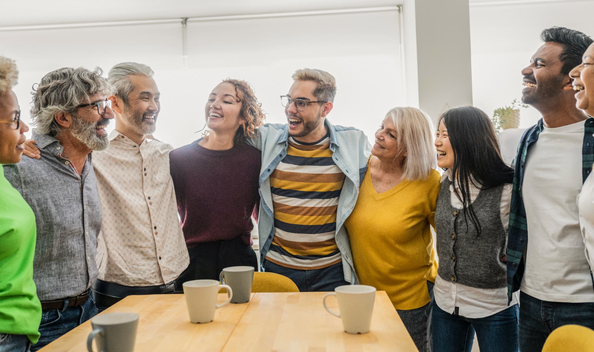 A diverse group of adults laughing together around a table